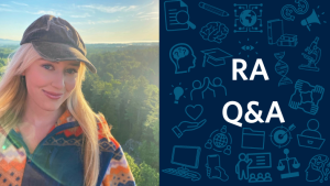 Kailey smiling standing in front of a beautiful forest view. She is wearing a colourful sweater and a black hat. Next to her is text saying RA Q&A and some fun research and psychology related symbols.